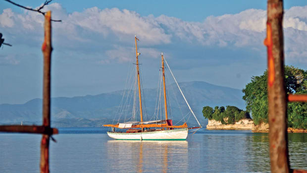 The schooner Charlotte is framed by mainland Haiti’s green mountains as she rests for a month in the quiet harbor at Port Morgan, Isle a Vache. Photo by Ian Ridgeway