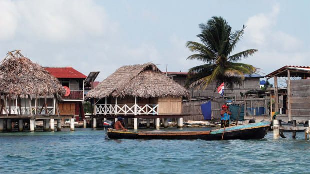 Guna men make their way through the village in a large dugout canoe also known as an “ulu”