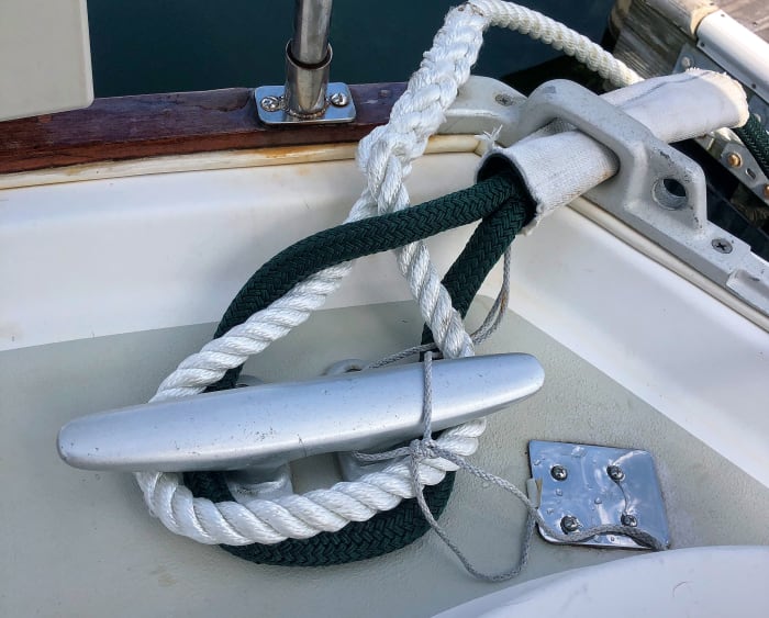 The author’s technique for doubling up dock lines on a single cleat—note the chafing gear 