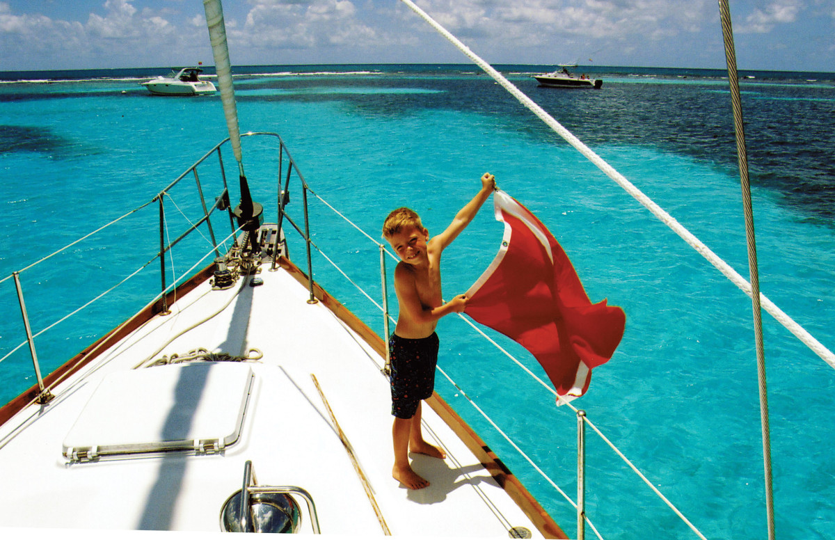 A young sailor gets his boat’s “diver down” flag ready off Key Largo, Florida. Photo by SAIL reader John Cole.