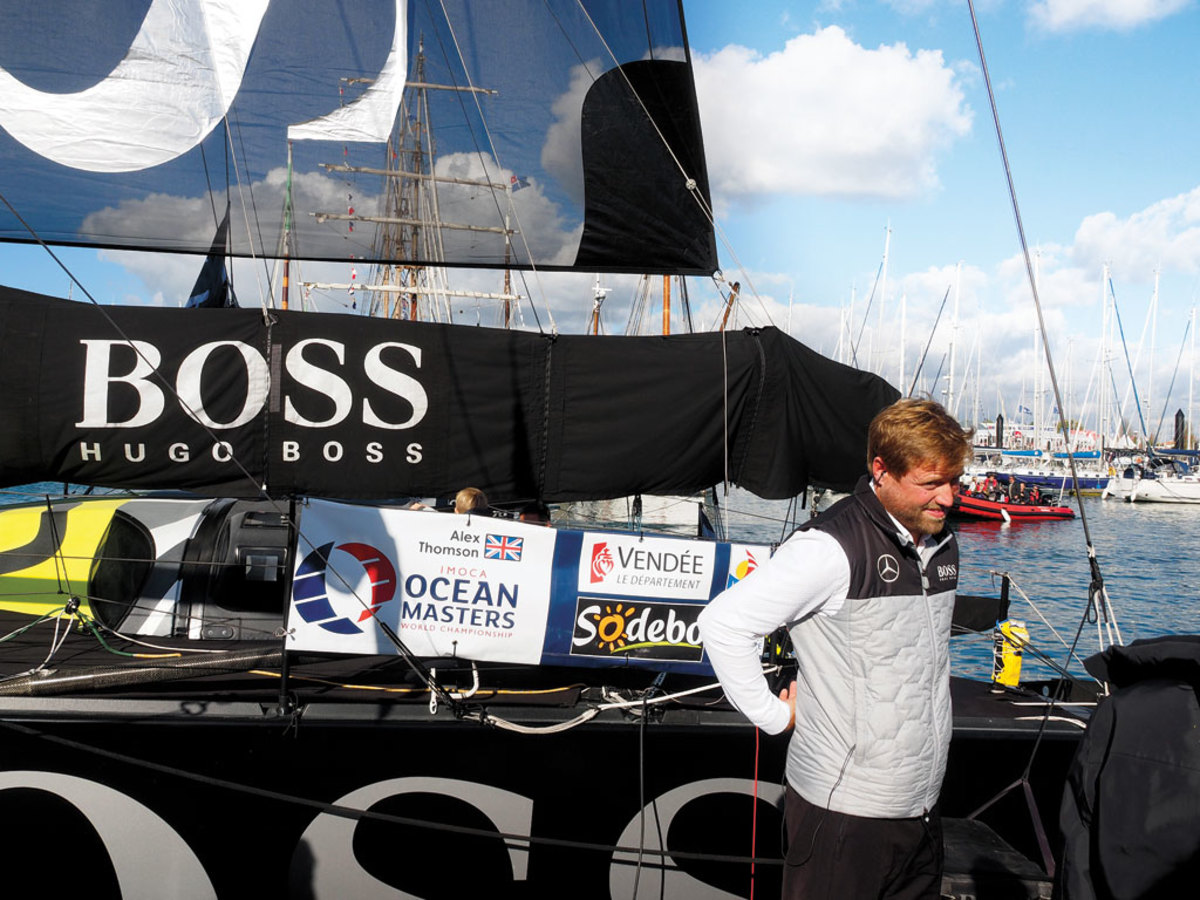 Alex Thomson on the dock in Les Sables d’Olonne, wearing earbuds to drown out the roar of the madding crowd, the day before the start of the Vendée Globe this past November