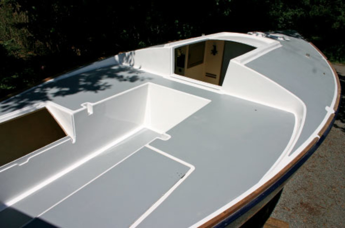 The finished deck before the new deck gear was installed: what a difference. The deck was painted first with two-part polyurethane and gray non-skid deck paint. After masking, the Interdeck paint was rolled over the non-skid areas.  Hatches were painted before being installed on the boat