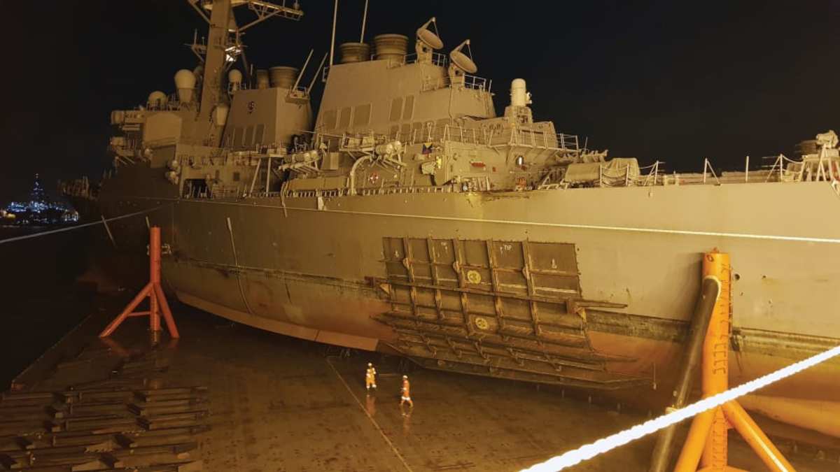  The USS John S. McCain was carefully loaded aboard a heavy-lift transport for transfer to a repair facility in Japan.   