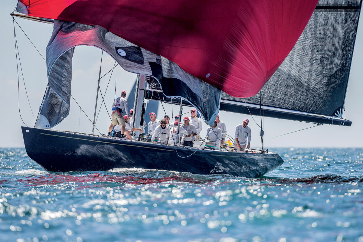 The crew of Defender does a sail change with the competition in hot pursuit