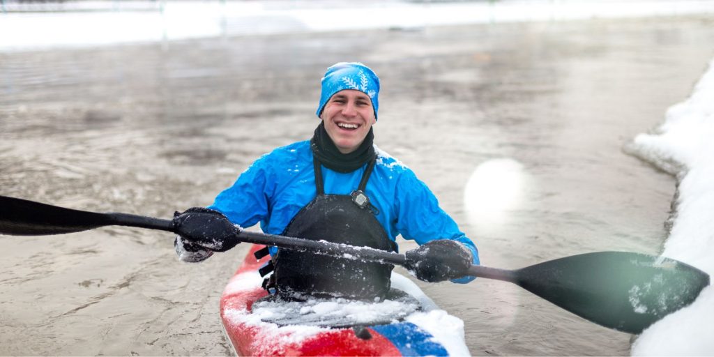 Happy Kayaker driving kayak on winter and laughing