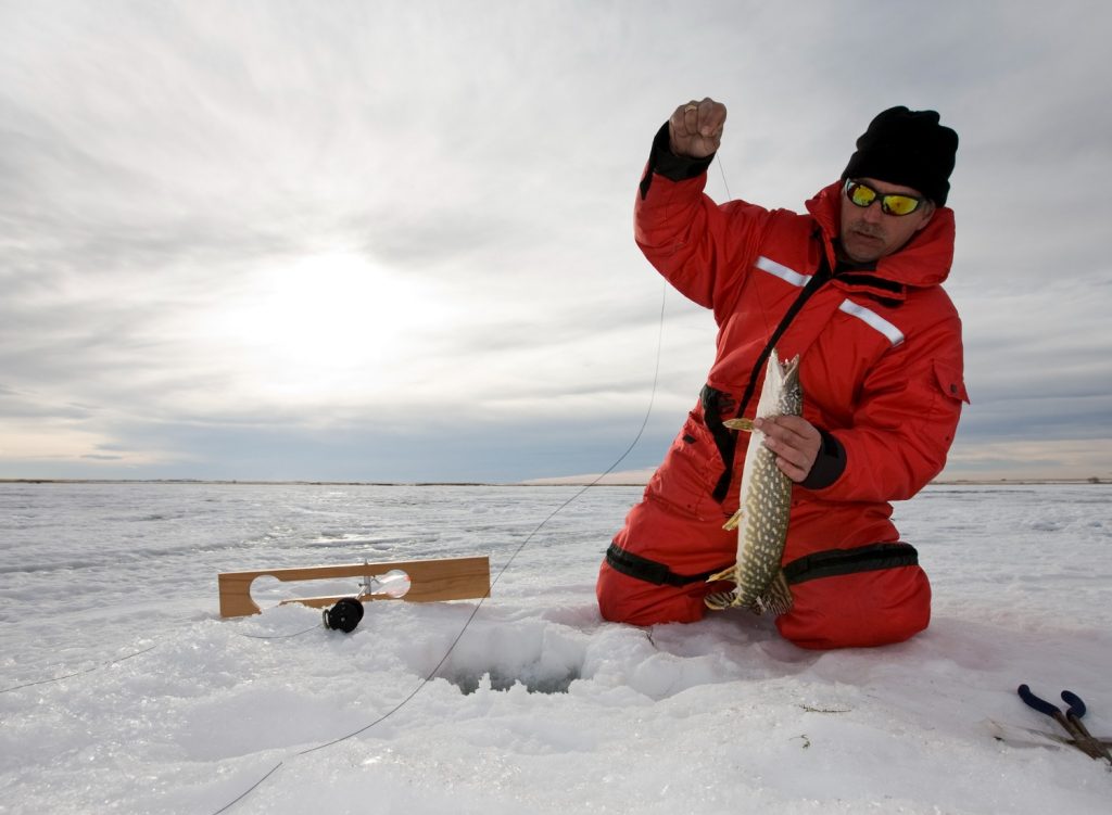 Man retrieving ice fishing catch