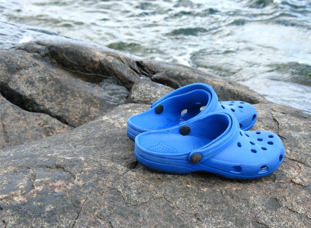 Pair of Crocs shoes near the ocean